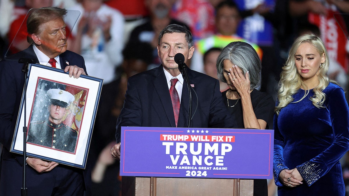 Republican presidential candidate and former President Donald Trump holds a portrait of Nicholas Douglas Quets