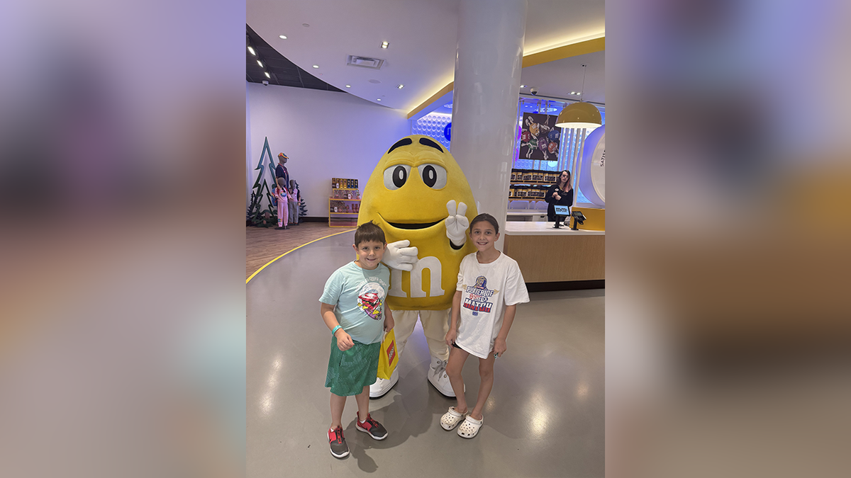 Preston Patton with her sister next to a giant M&M pet